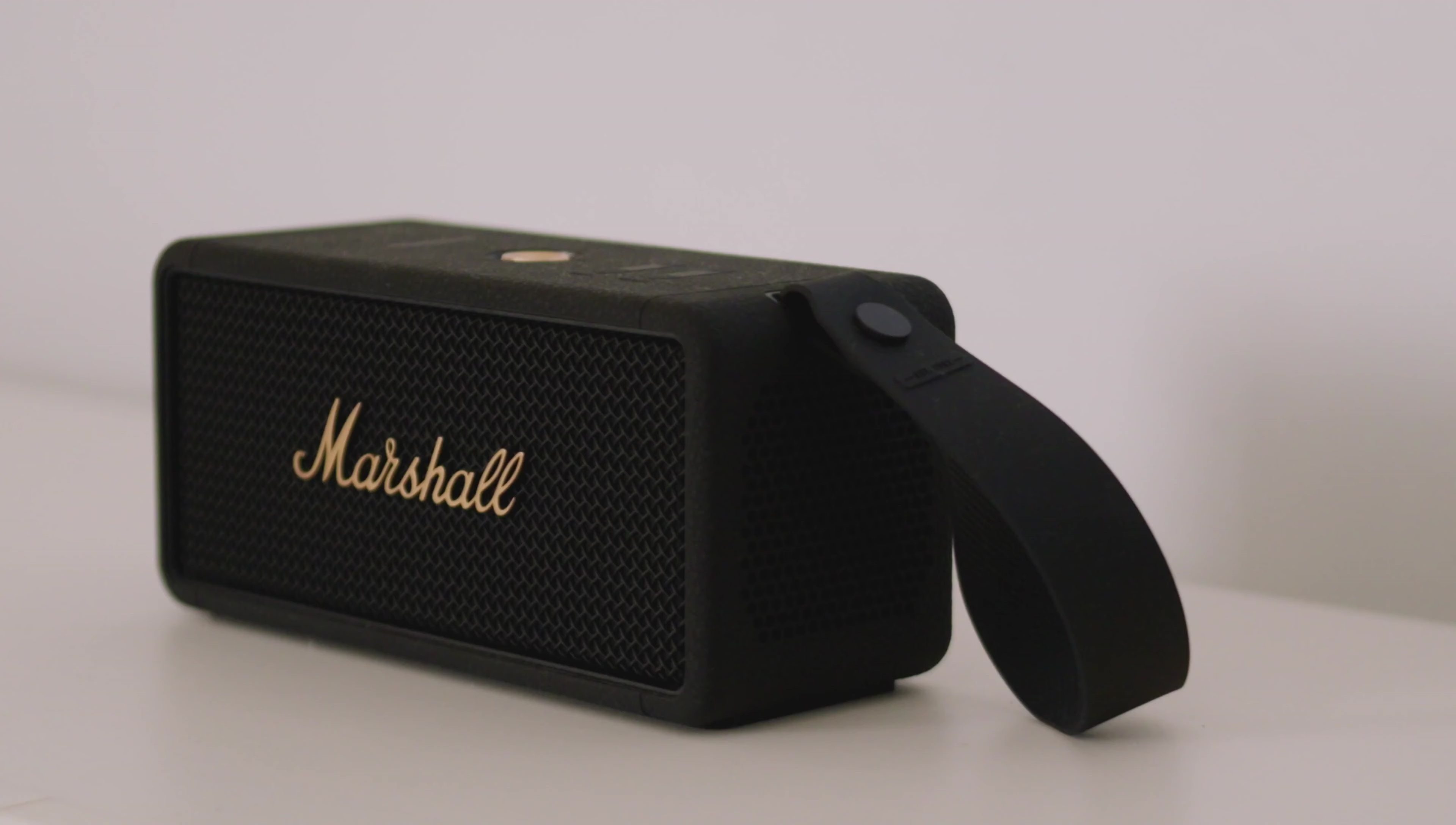 The speaker being held and examined, showcasing its size and build.