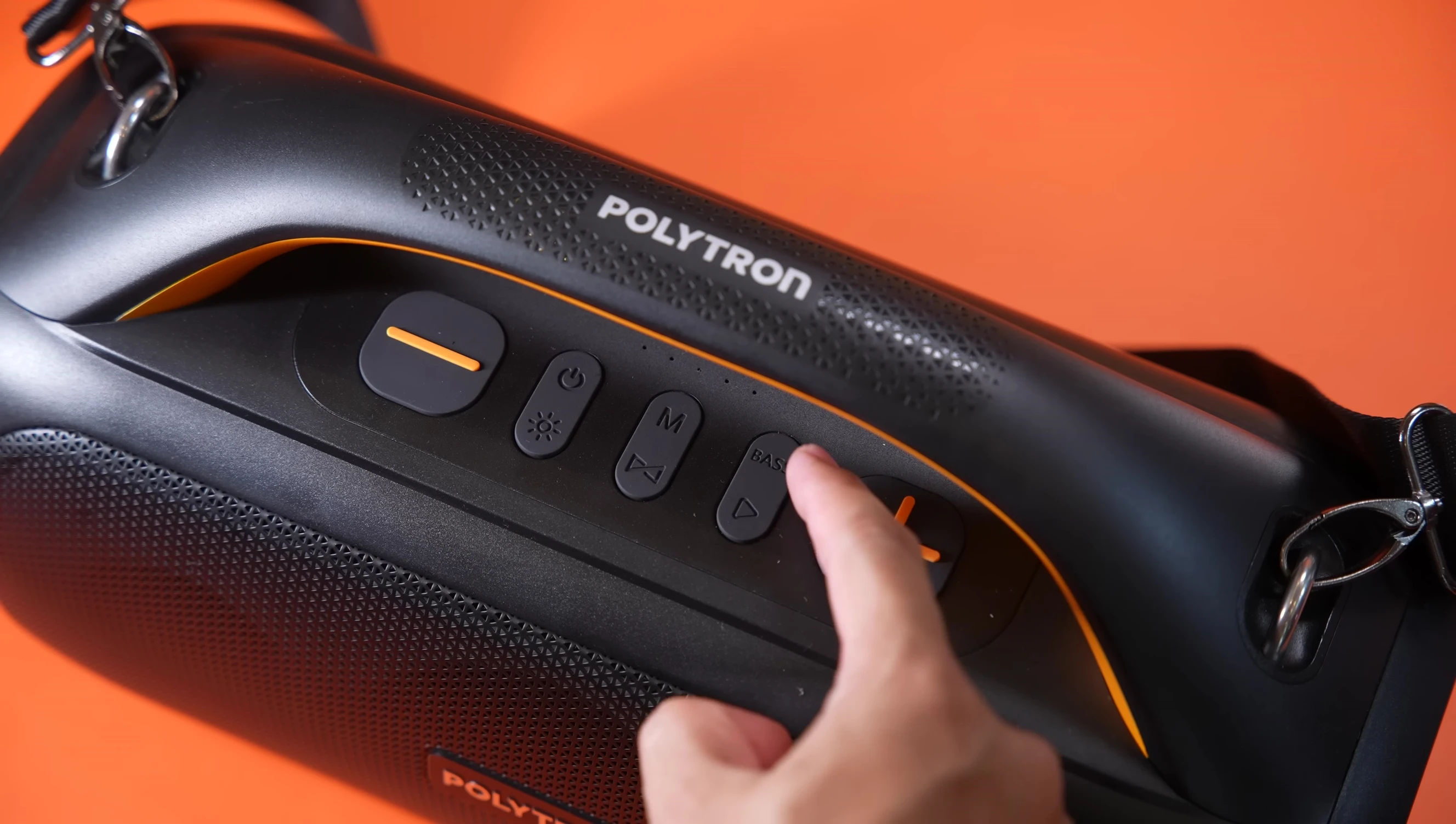 The bass boost button on the top of the speaker is shown.