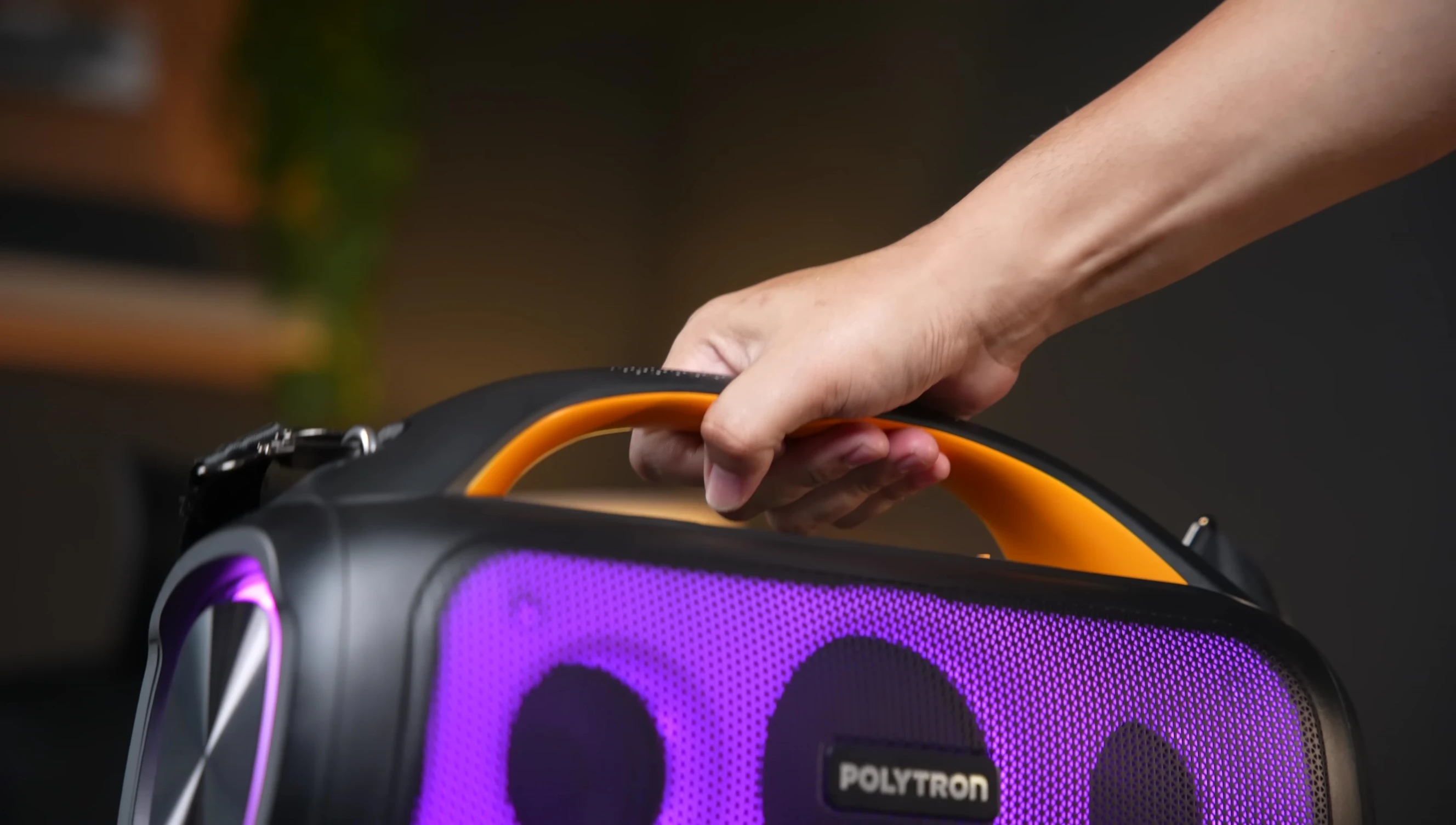 Close-up of the Polytron PartyMax speaker showcasing its black and orange design and handle.