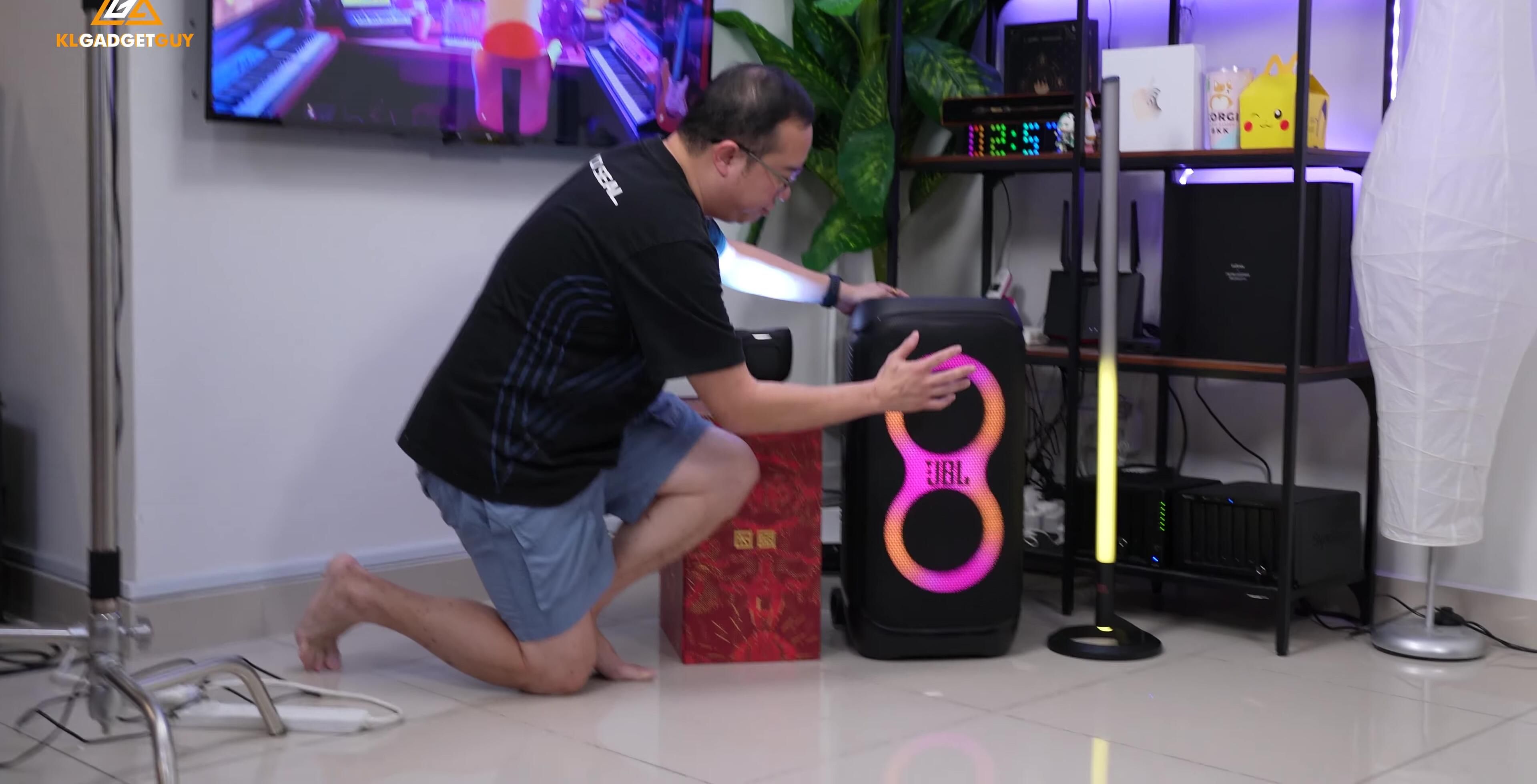 Close-up of the front of the speaker, showcasing the woofers and RGB lighting