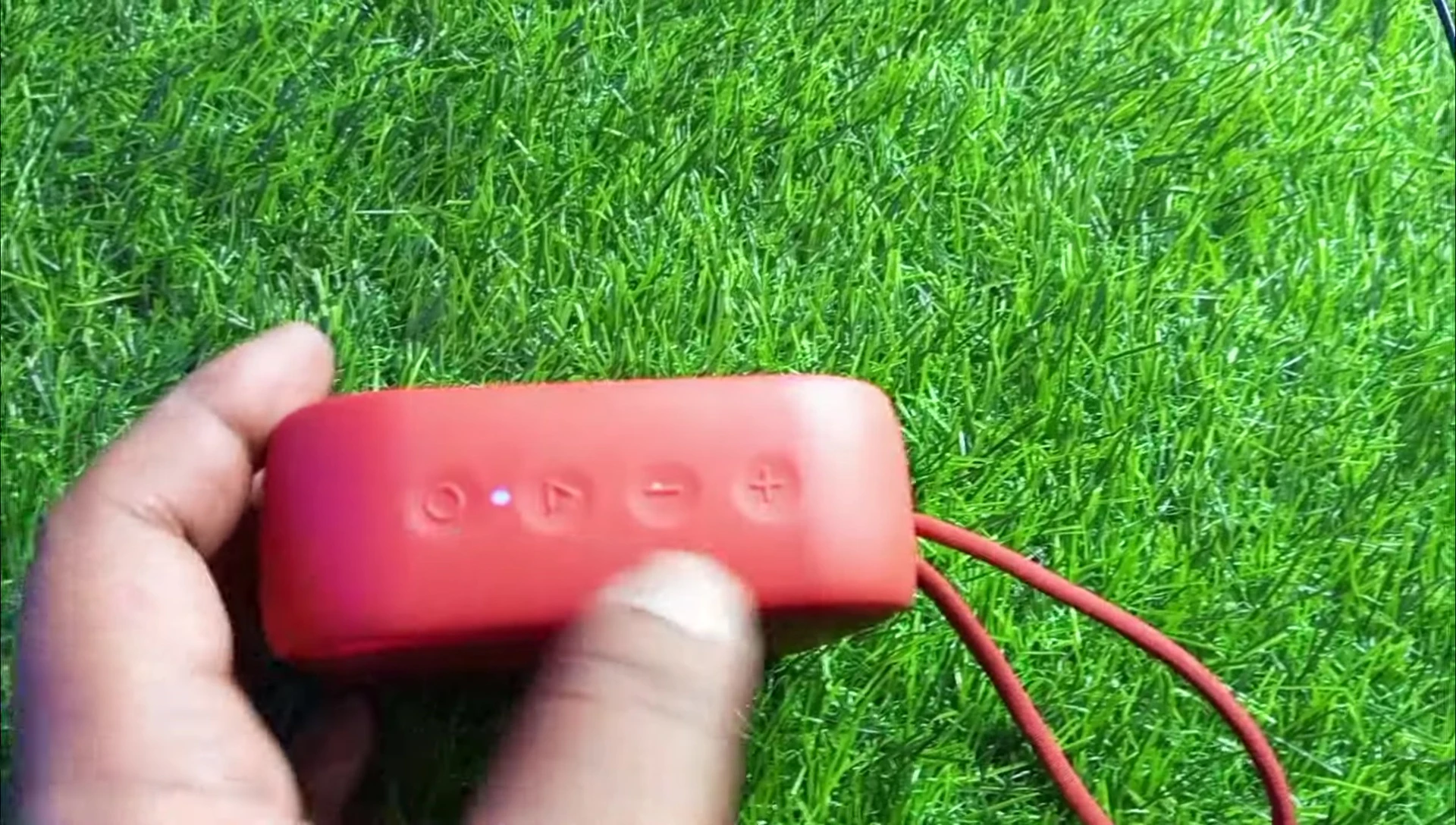 Close-up of the top of the speaker displaying the control buttons.