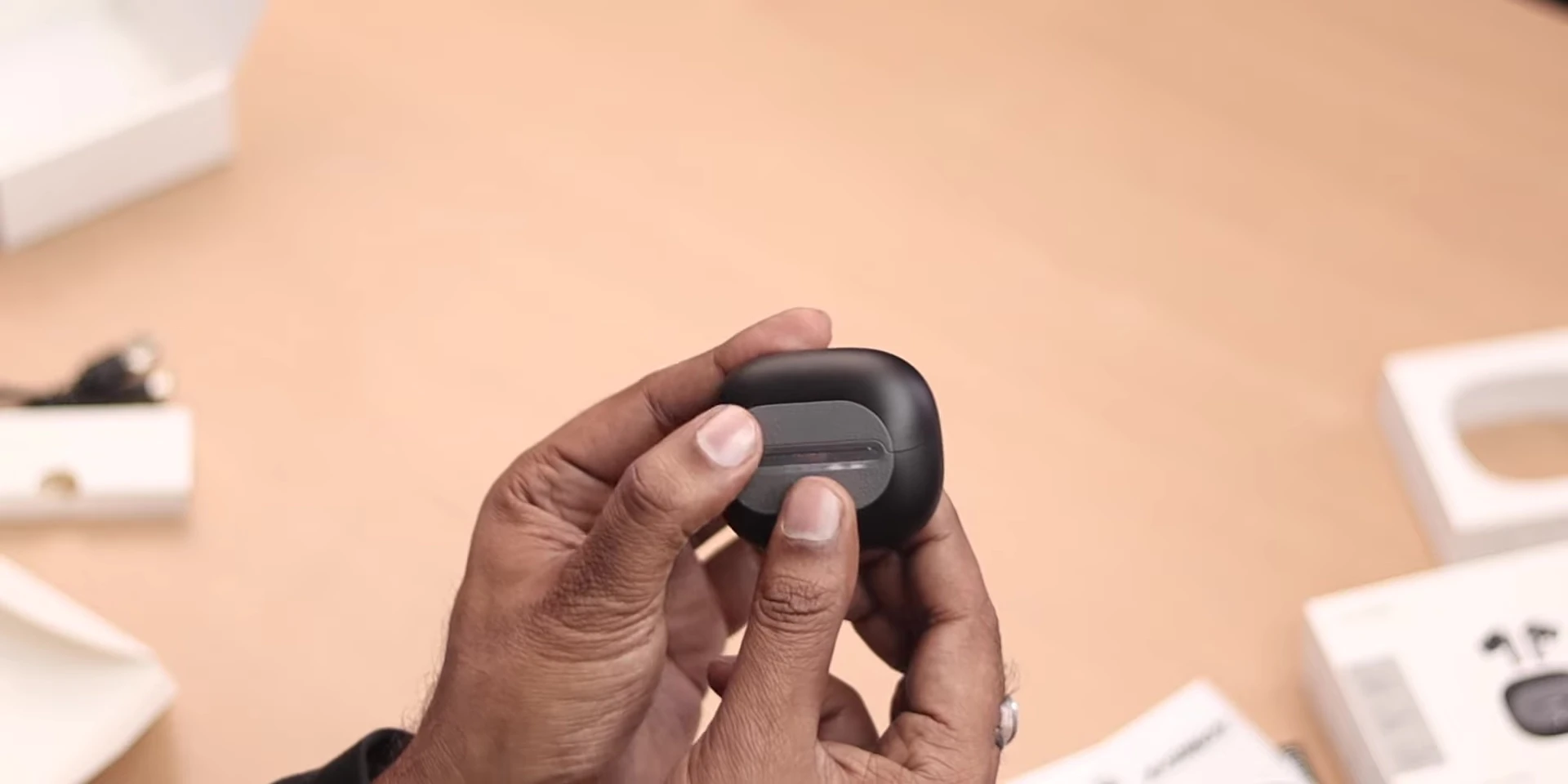 Earbuds inside the charging case showing the magnet.
