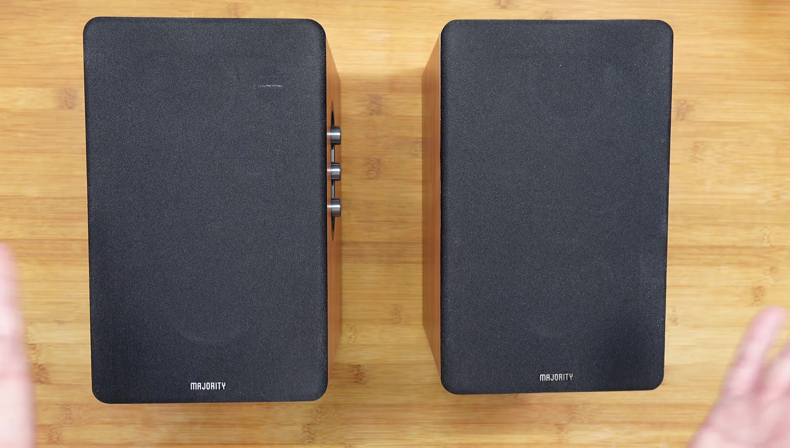 Majority D100 speakers positioned on either side of a TV.