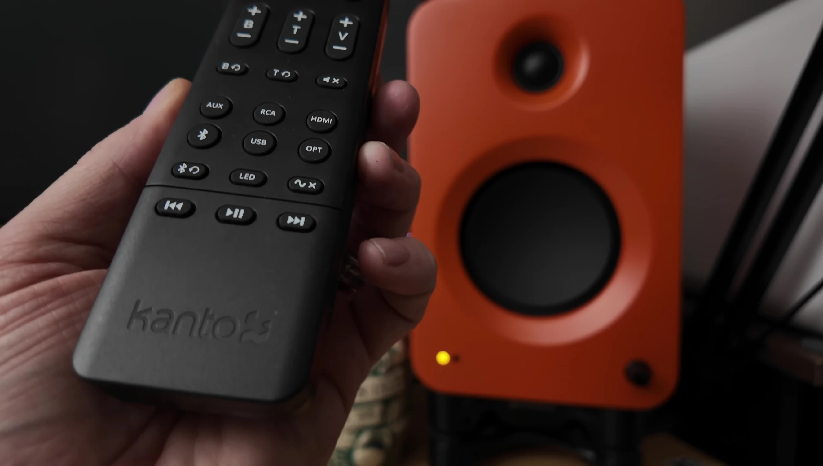 Remote control being used to adjust the speakers' sound.
