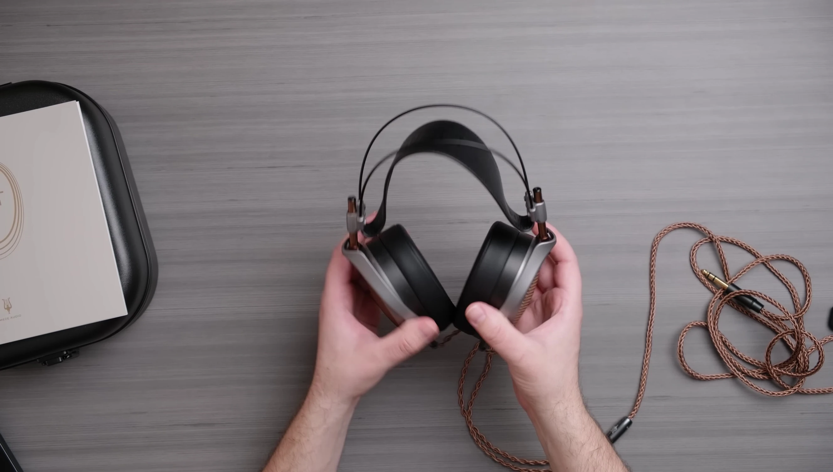 The reviewer demonstrating the swivel and tilt mechanism of the headphones.