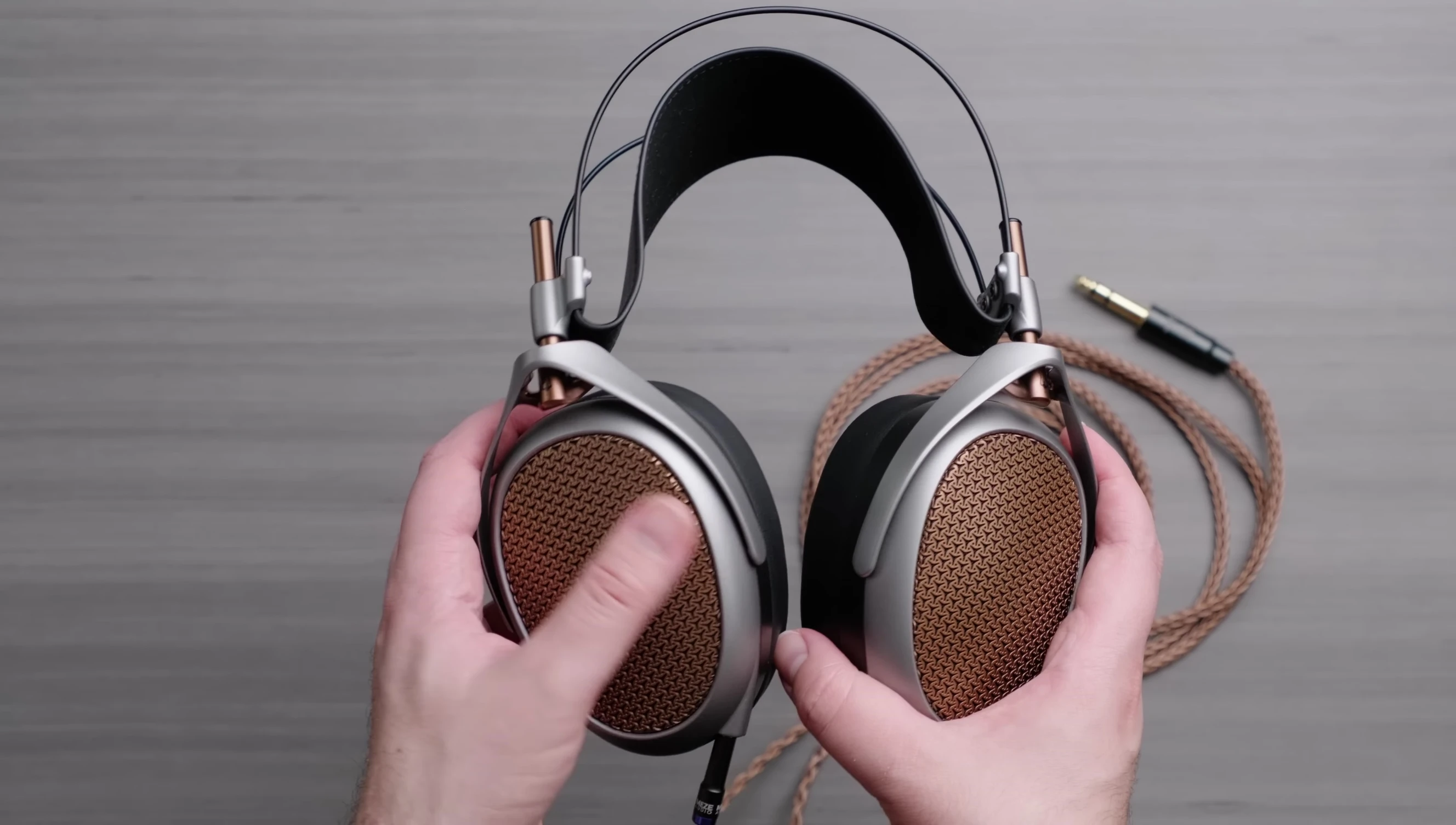 Close-up of the Meze Audio Poet headphones being taken out of their box.