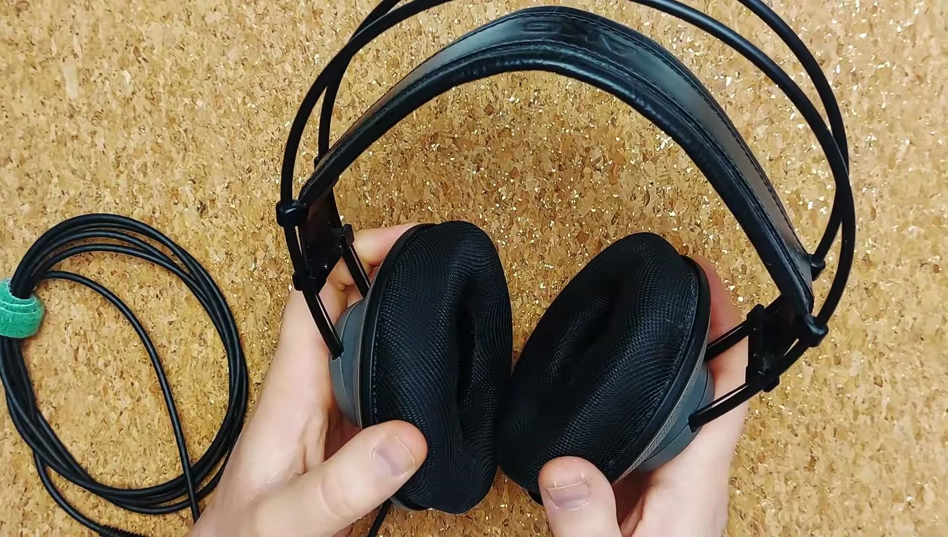 The reviewer holding and demonstrating the AKG K501.