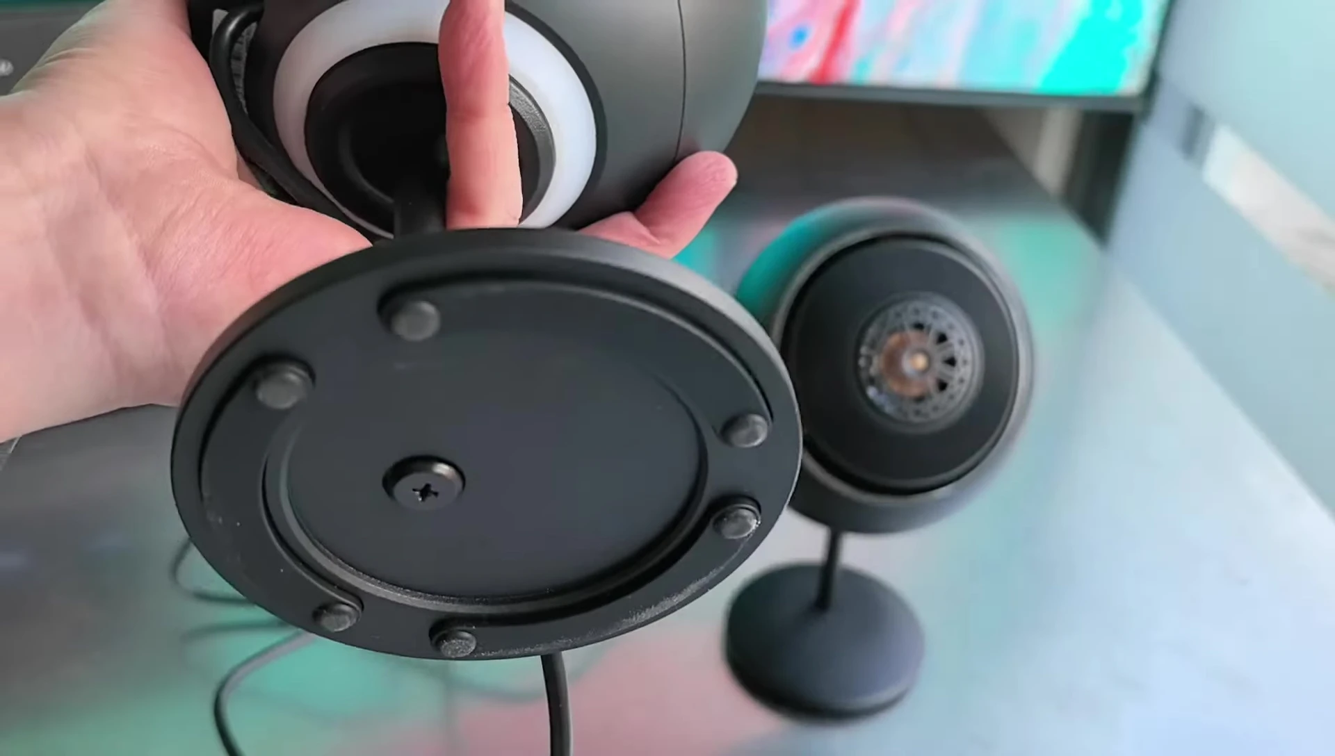 The metallic stand attached to one of the speakers.