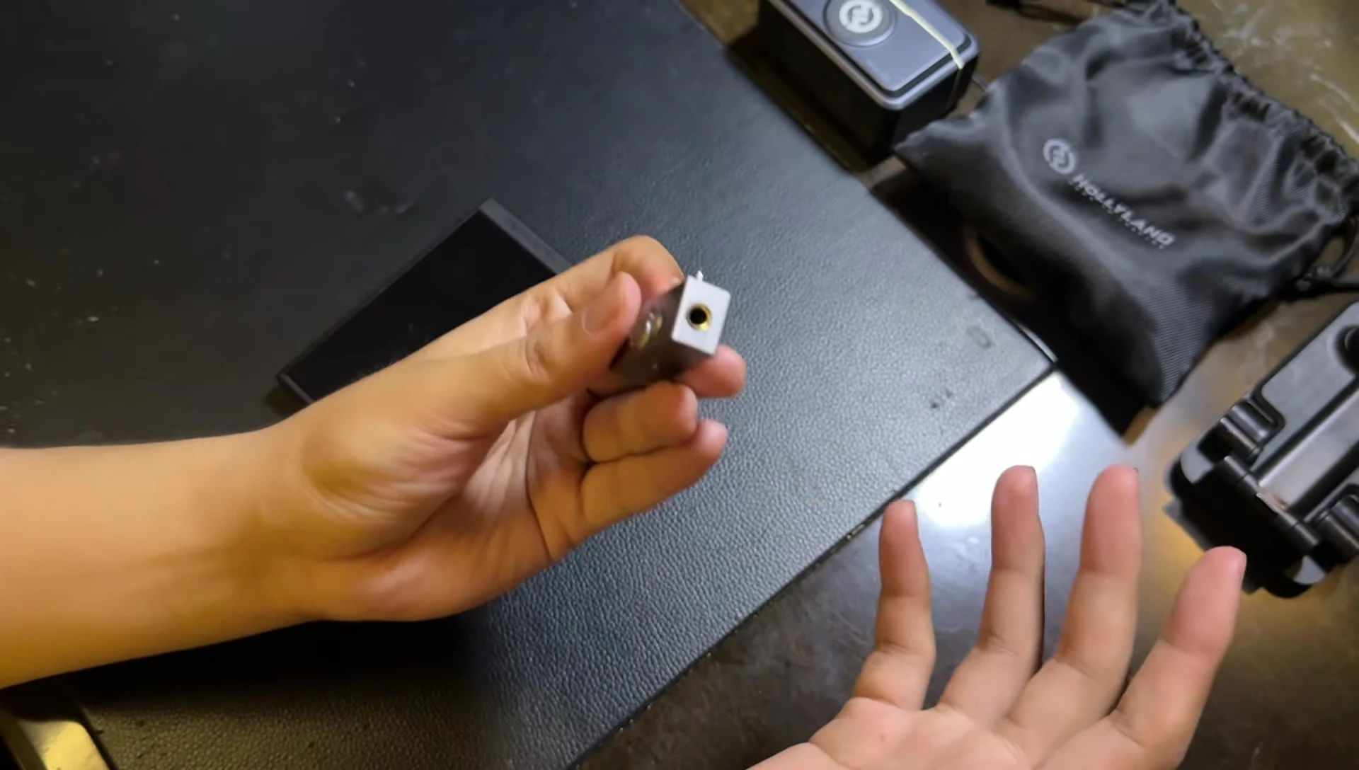 The reviewer comparing sizes of the three dongles