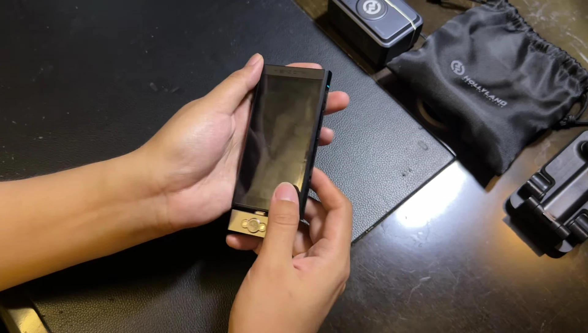 The reviewer holding the dongle and talking about sound quality