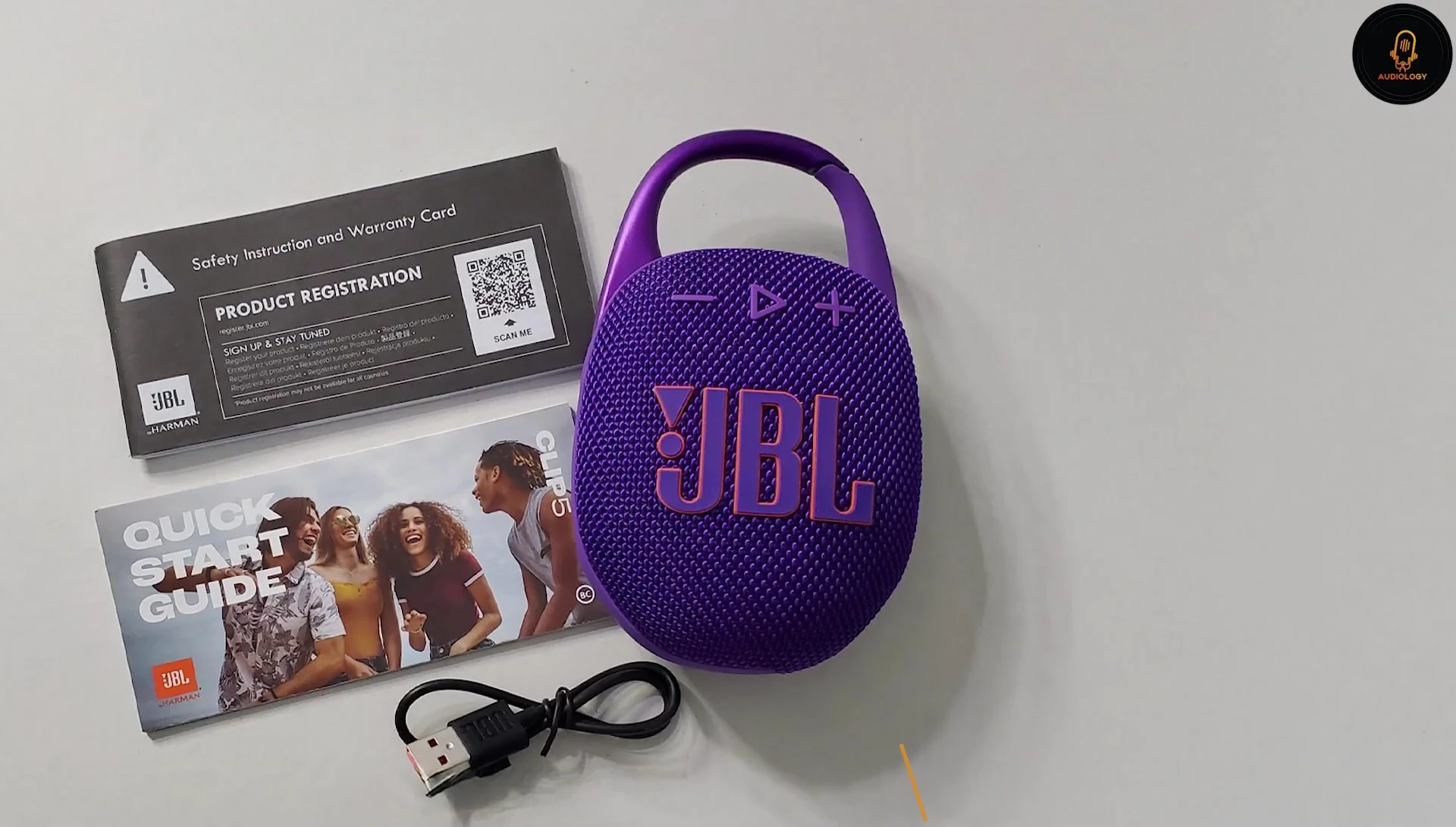 JBL Clip 5 attached to a backpack, showcasing its portability