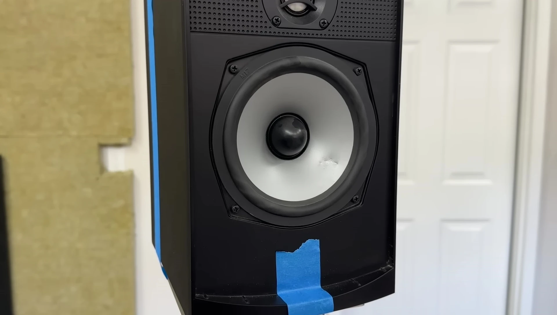 The speaker with dents in both the tweeter and midwoofer.
