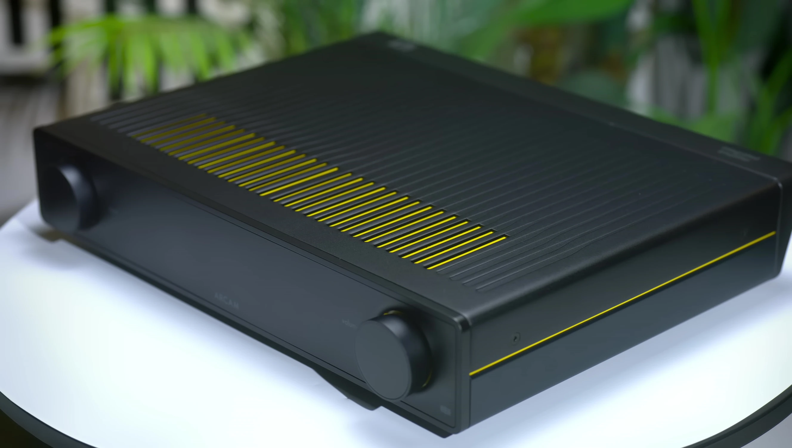 Close-up shot of the Arcam A25's front panel highlighting its modern design and yellow accents.