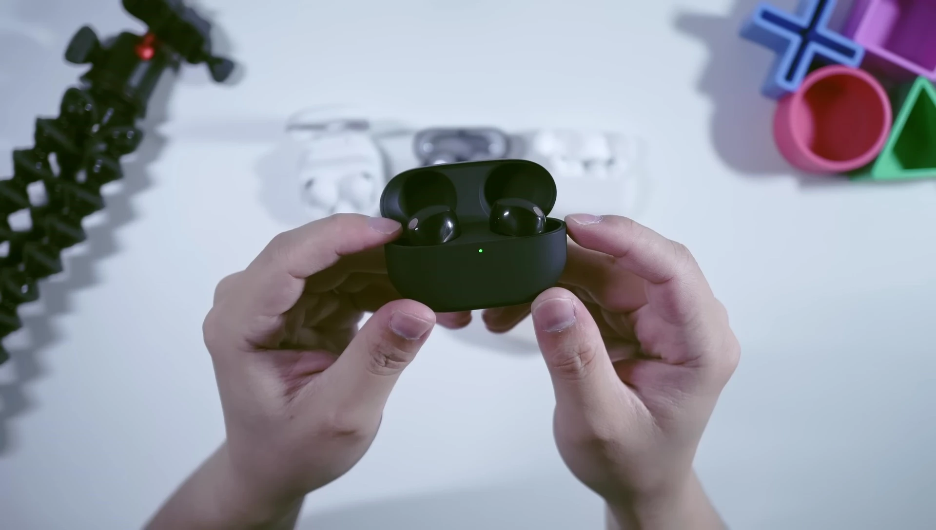 Close-up shot of the Sony WF-1000XM5 earbuds in a hand.