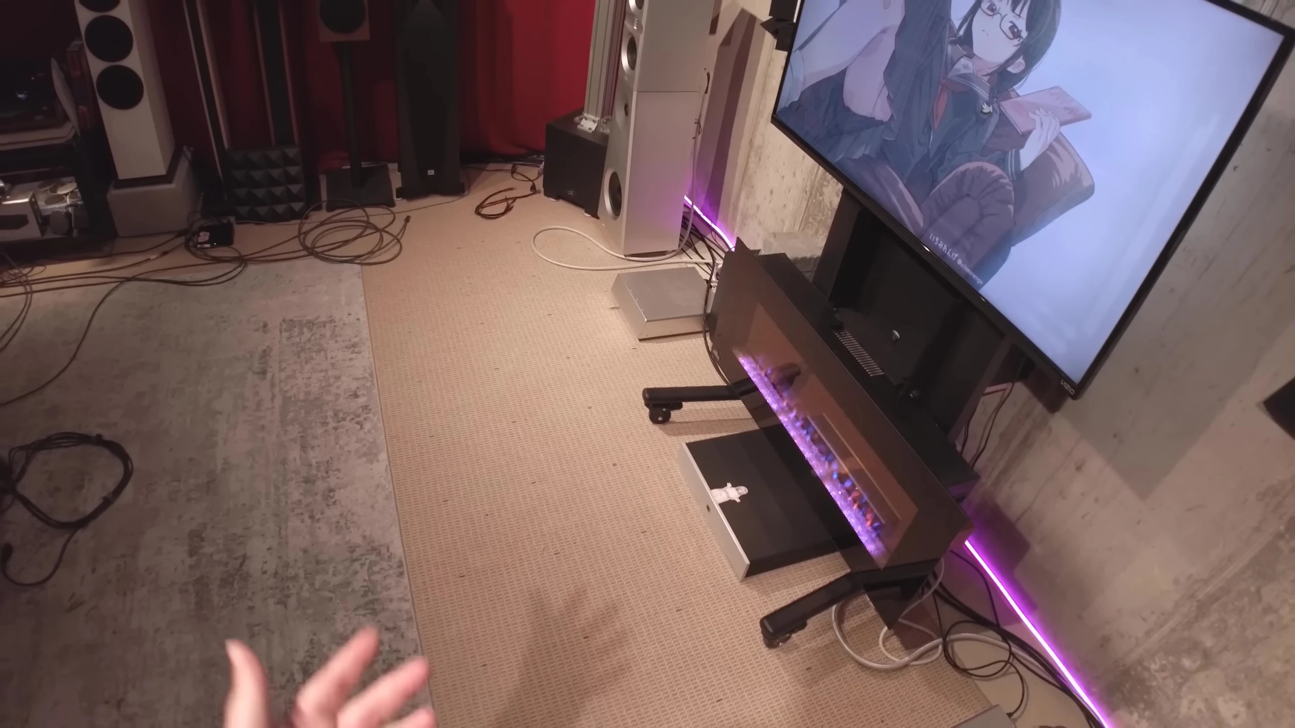 The reviewer gestures towards the speaker setup